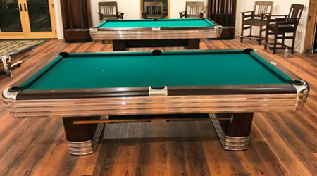 A pair of restored Centennial billiard tables from the side