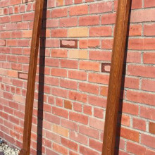 An antique wooden Babcock cue rack that holds 12 cues