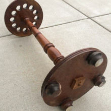 A restored round wooden European 12 cue rack